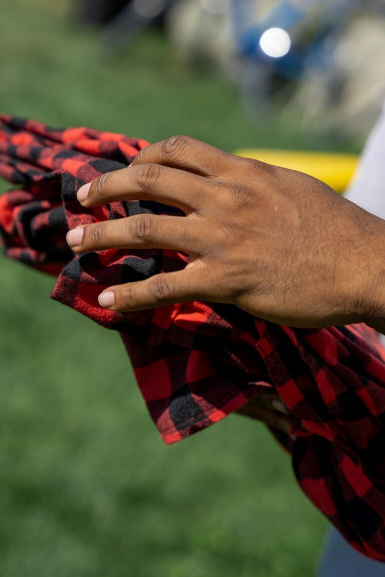 Close-Up Photo of a Person Holding a Plaid Blanket